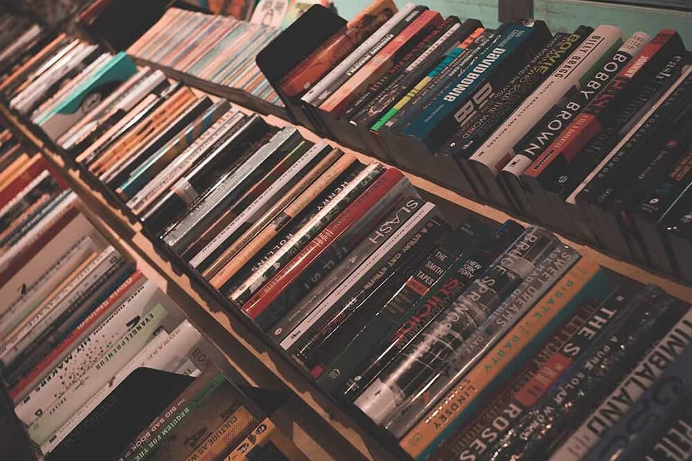 A close-up view of several stacked books arranged on a shelf.