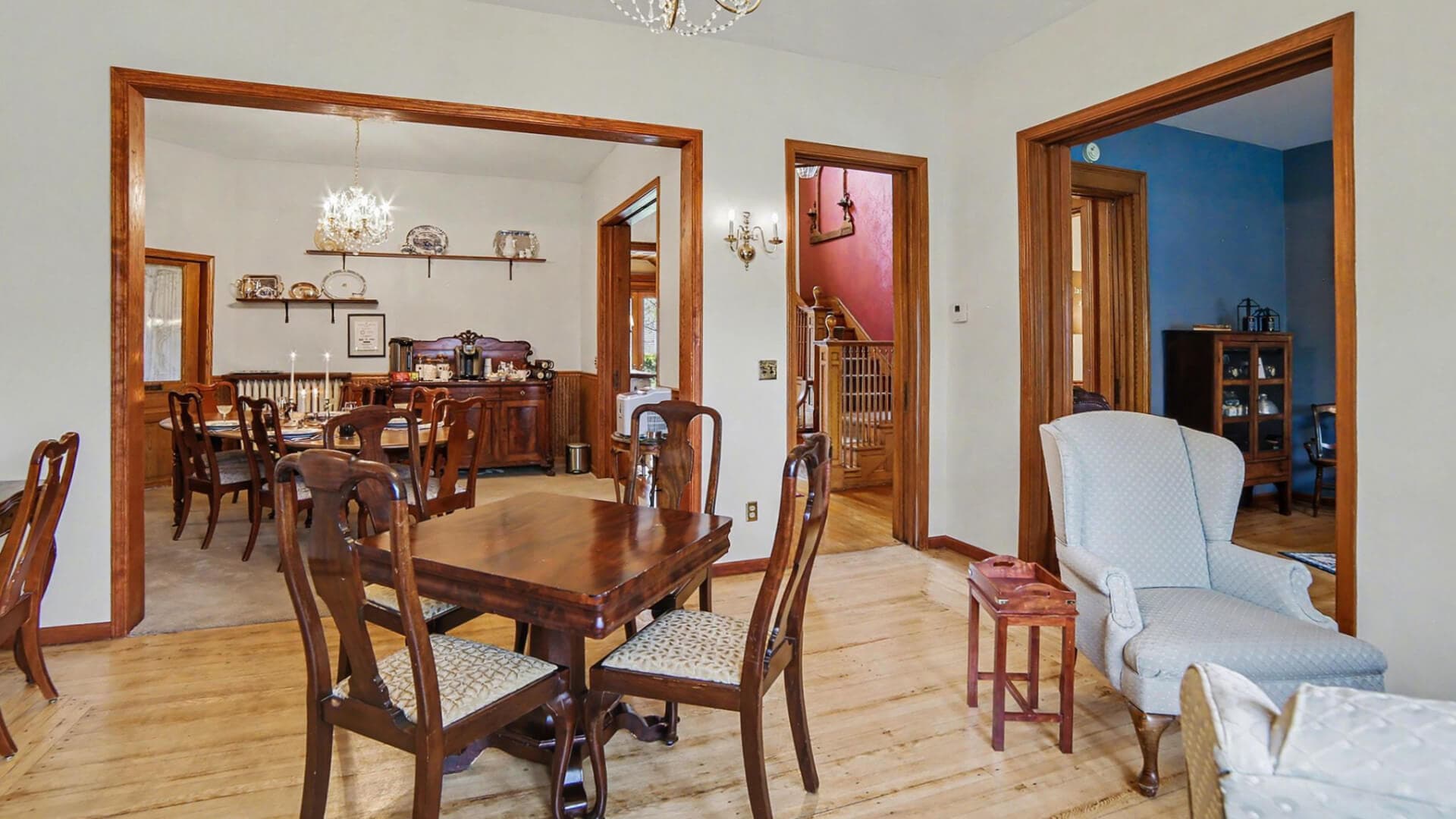 Interior view of a dining area with wooden furniture and multiple doorways leading to adjacent rooms.